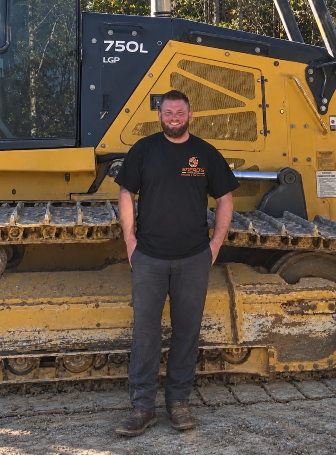 Chris Snead, owner of Snead's Outdoor Services, standing in front of a dozer
