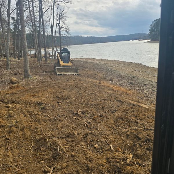 Skid steer regrading a lakeside bank