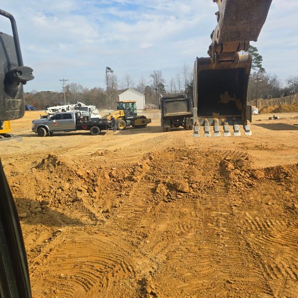 Excavator bucket over freshly graded ground on a commercial site