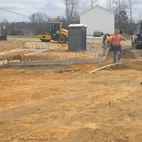 Wheel loader and crew finishing grade around new curbing