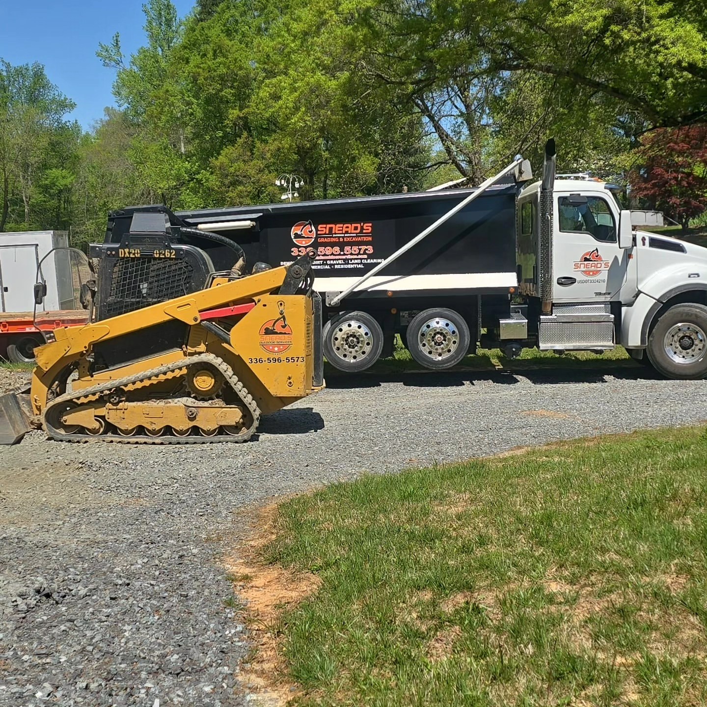 Dozer cutting a clay access road through standing timber