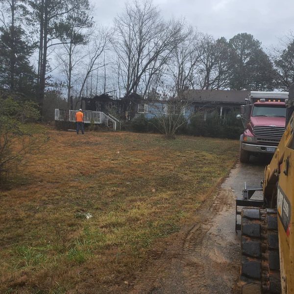 Crew, dump truck and excavator clearing a residential lot