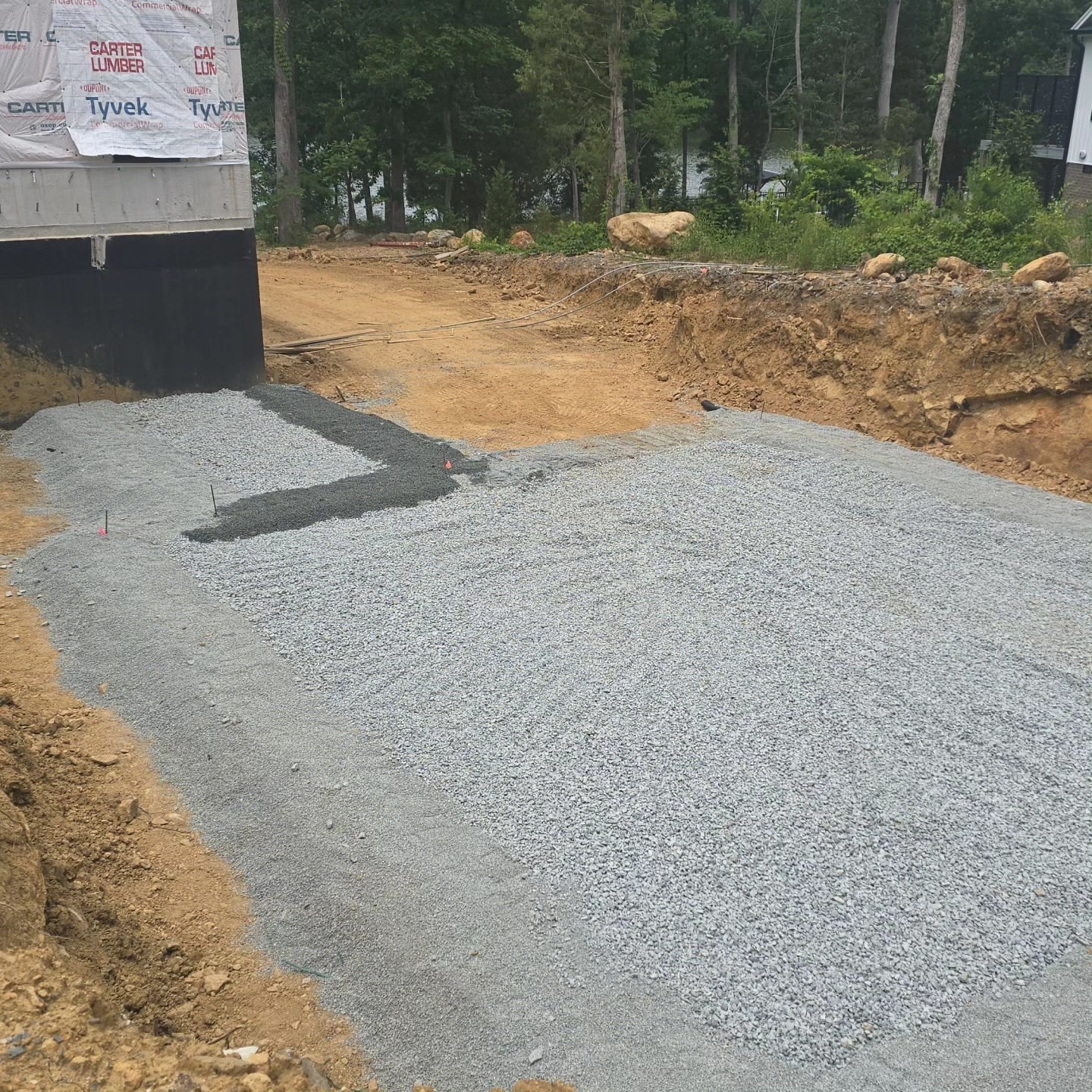 Excavator bucket over freshly graded ground on a commercial site