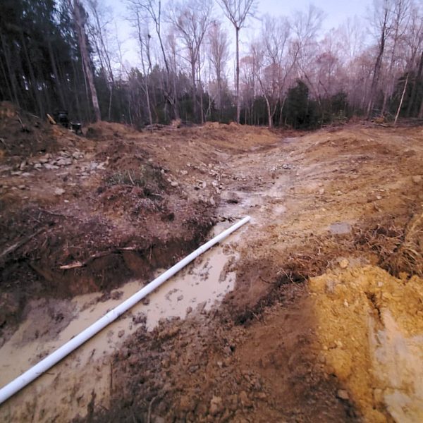 White PVC line bedded in an open trench