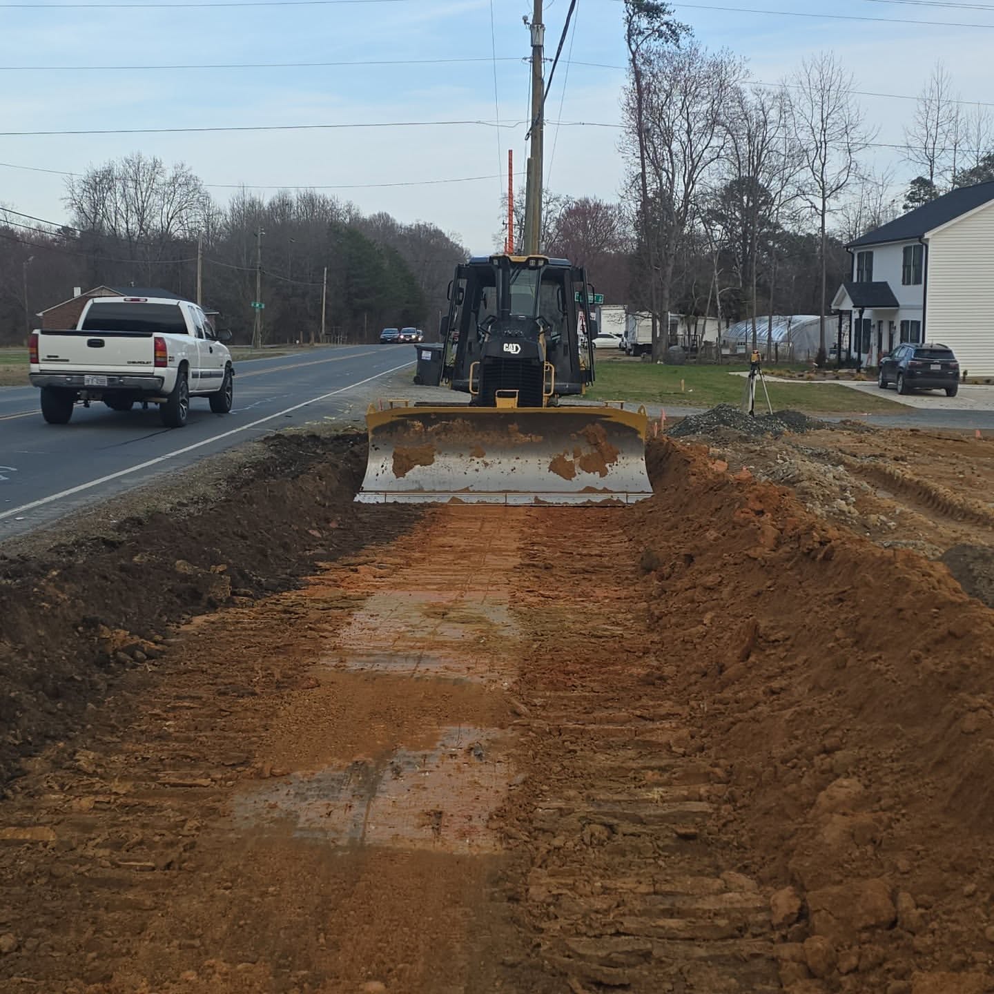 Excavator and dozer moving red clay on a cut-and-fill job