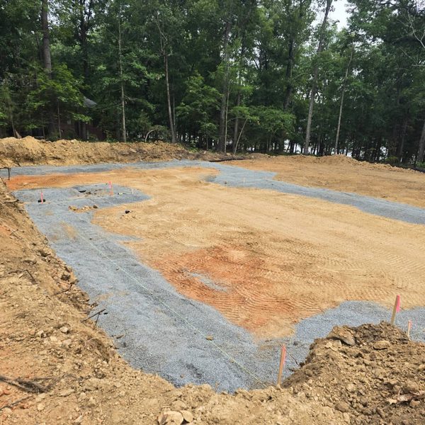Excavated drain field bedded with fabric and stone