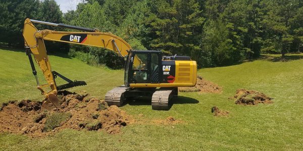 Excavator digging out the pond basin